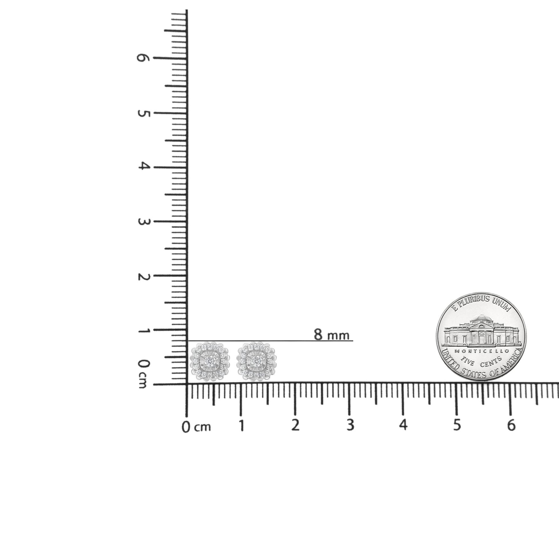 Pair of white metal square-shaped earrings with cluster of round white gemstones in miracle and prong settings, shown on a ruler for size reference, front view.