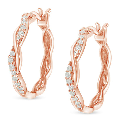 Pair of rose-colored hoop earrings with wavy design and white round gemstones in pave setting, shown from a front angled view.