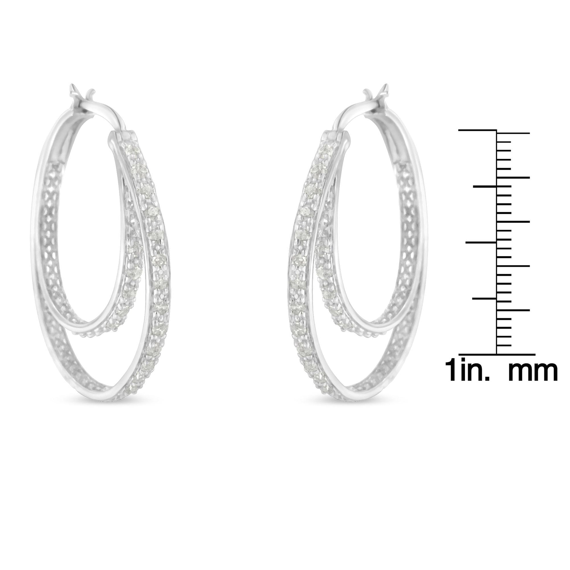 Pair of white metal double hoop earrings with pave-set round white gemstones, shown from a front angle next to a ruler for size reference.