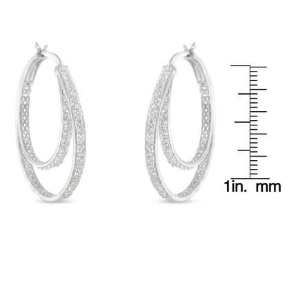 Pair of white metal double hoop earrings with pave-set round white gemstones, shown from a front angle next to a ruler for size reference.