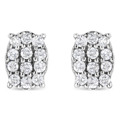 Front view of a pair of white metal oval earrings with multiple round white gemstones in prong settings.