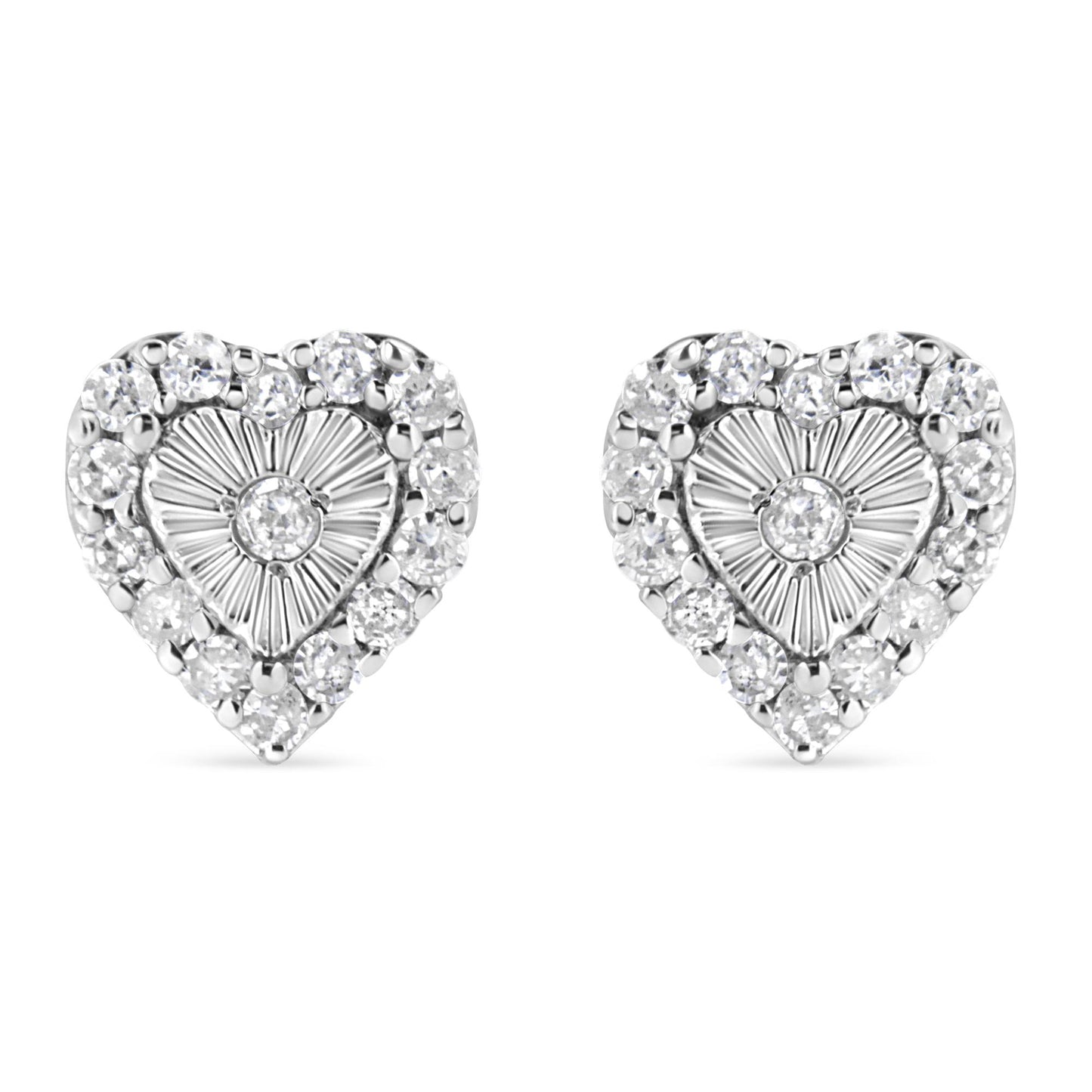 Front-facing view of a pair of white metal heart-shaped earrings with a central round white gemstone in miracle setting, surrounded by multiple round white gemstones in prong setting.