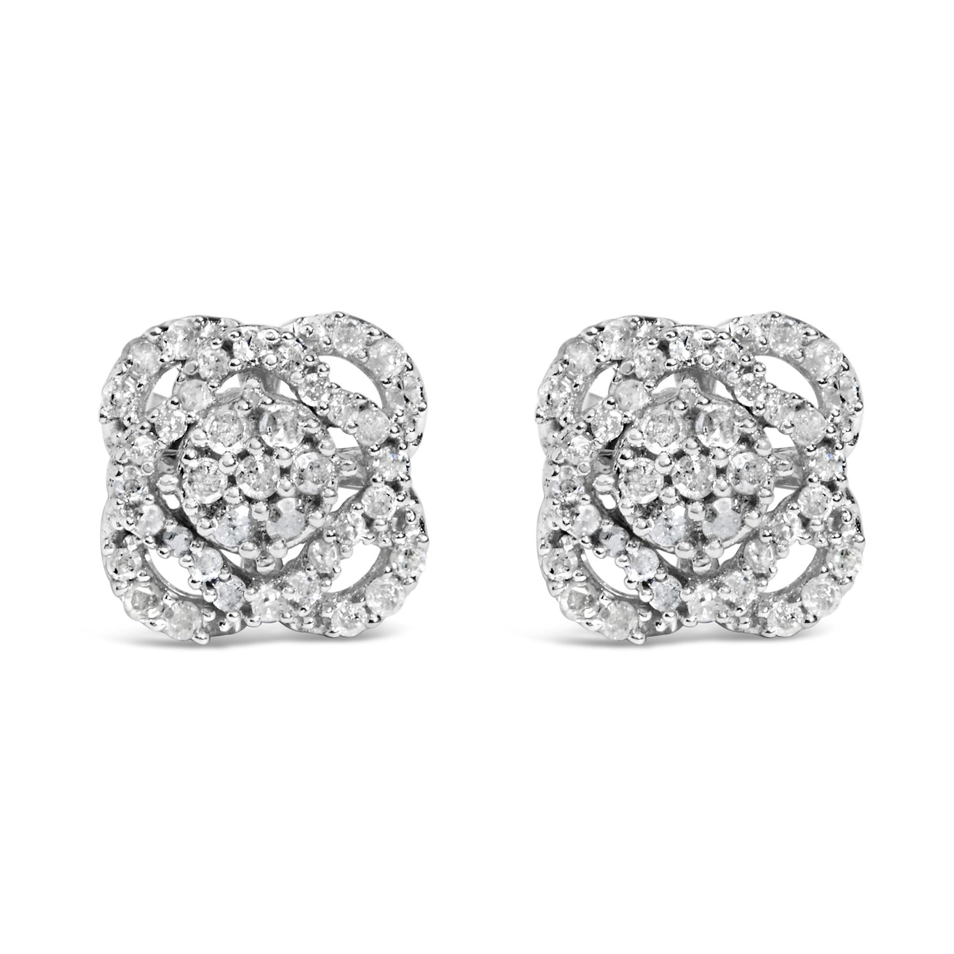 Front view of a pair of white metal stud earrings featuring multiple round white gemstones in prong settings arranged in a floral pattern.