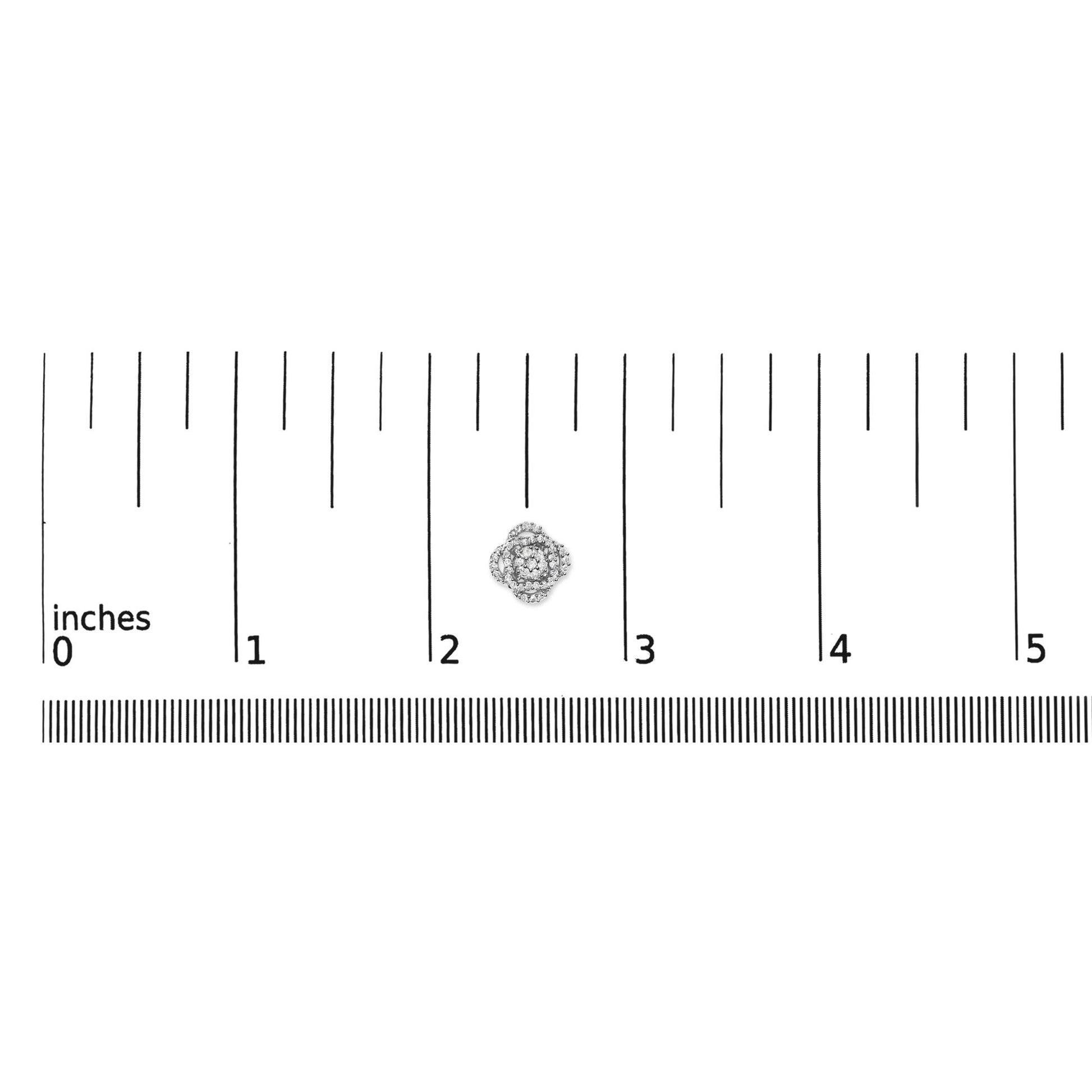 Top-down view of a white metal earring with round white gemstones in prong settings, placed on a ruler for size reference.