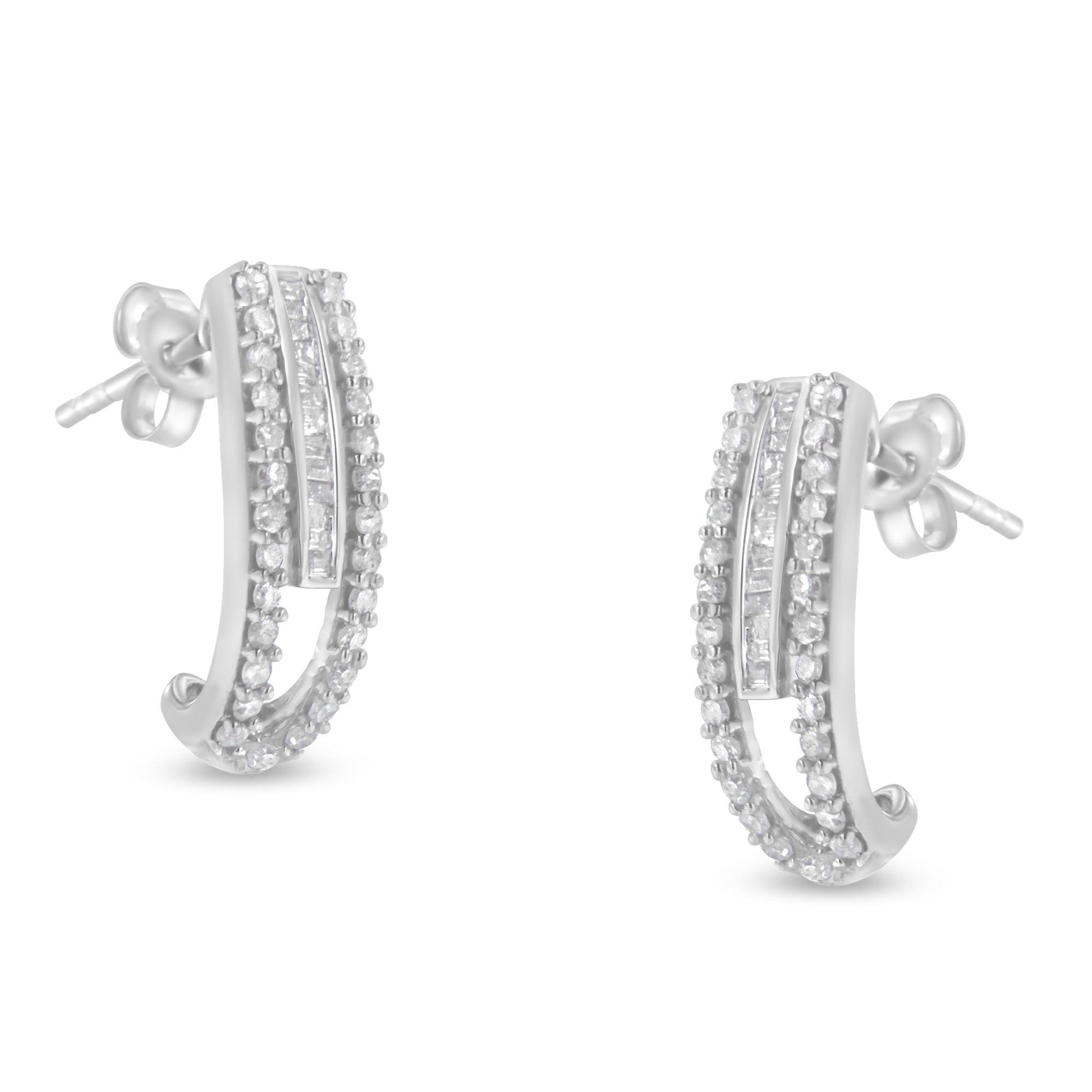 Pair of white metal earrings with curved design featuring rows of round prong-set white gemstones and a central channel-set row of baguette white gemstones, shown from front angle.