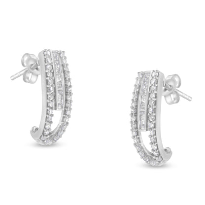 Pair of white metal earrings with curved design featuring rows of round prong-set white gemstones and a central channel-set row of baguette white gemstones, shown from front angle.