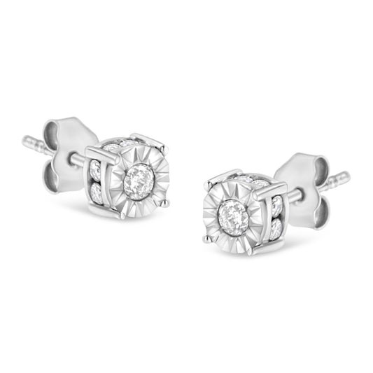 Pair of white metal stud earrings with round white gemstones in miracle and channel settings, shown from a front angle.
