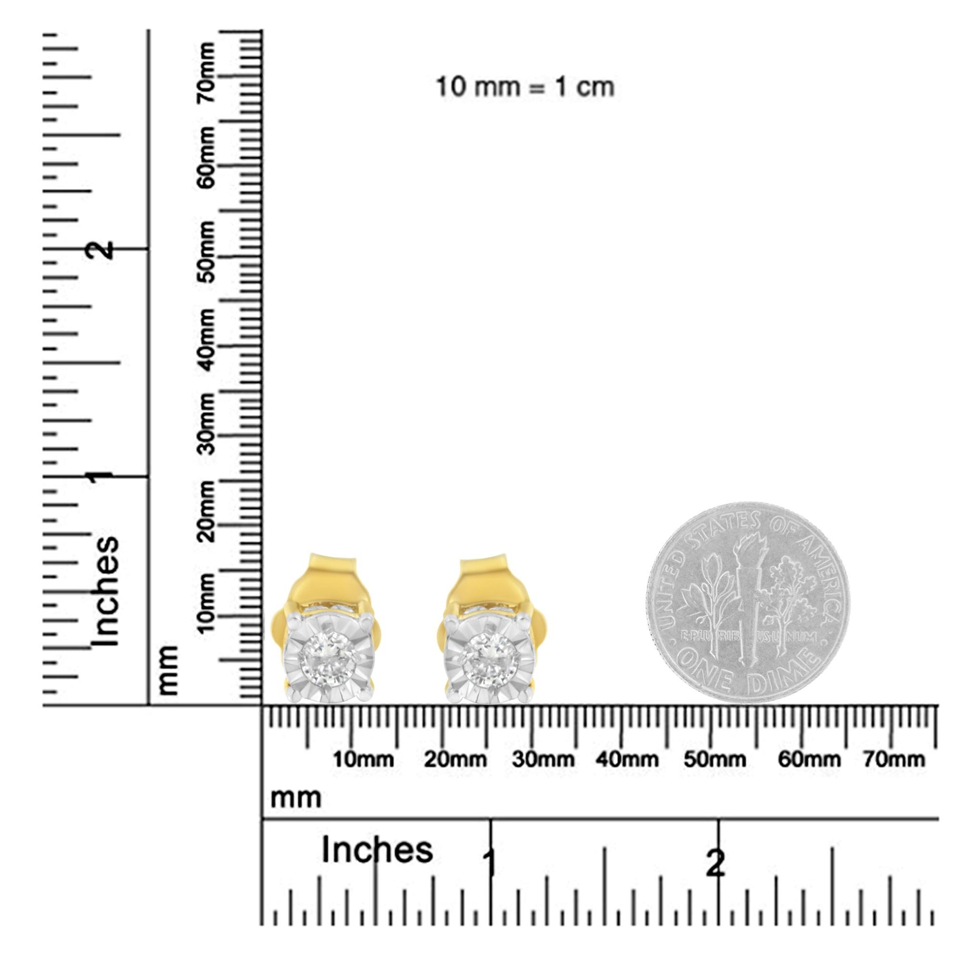 Front view of yellow metal stud earrings with round white gemstones in miracle setting, placed on rulers and next to a dime for size reference.