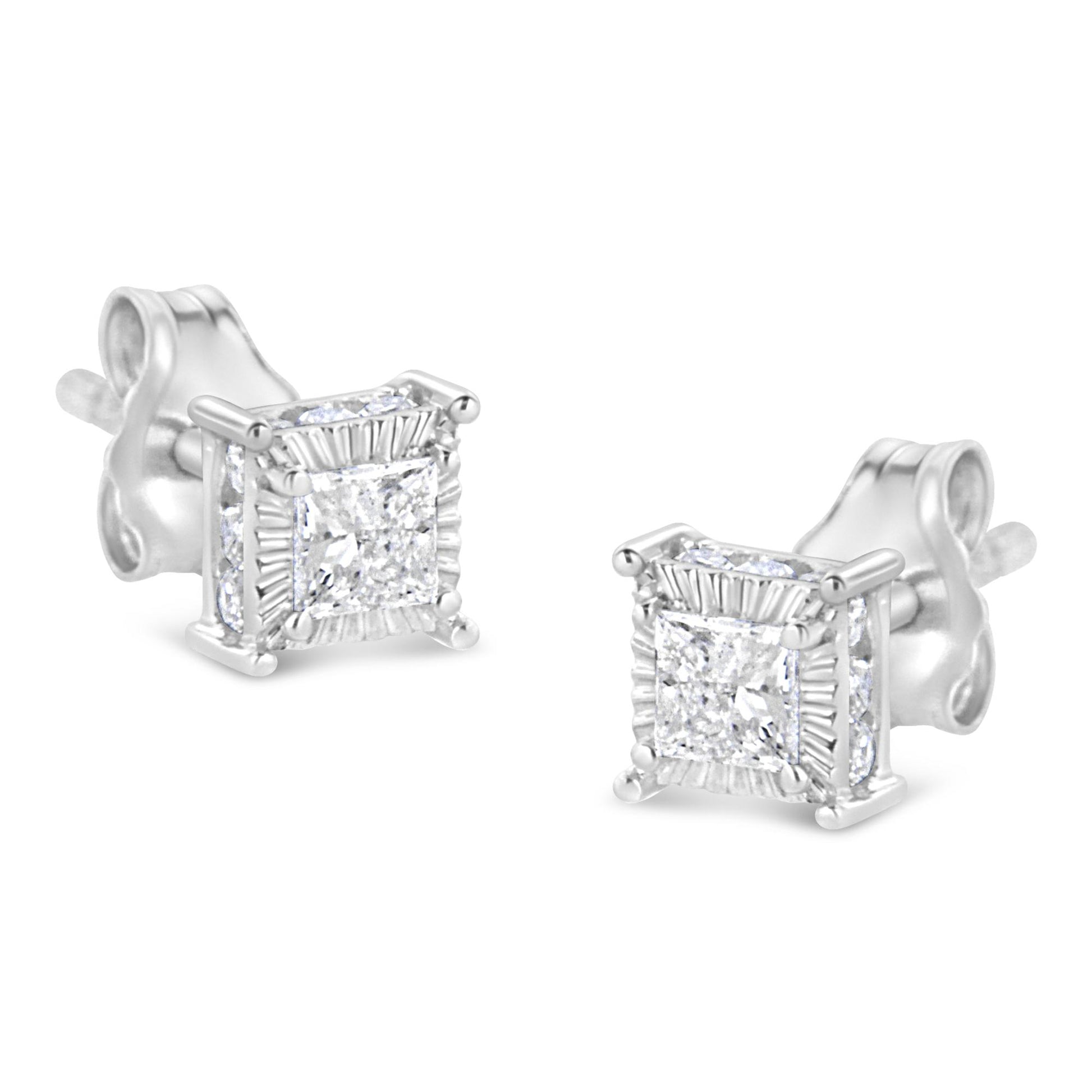 Pair of white metal stud earrings with princess shape white gemstones in the center surrounded by smaller round white gemstones on all sides, shown from an angled front view.