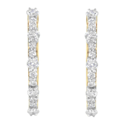 Front-facing view of yellow metal hoop earrings set with round white gemstones in prong settings.