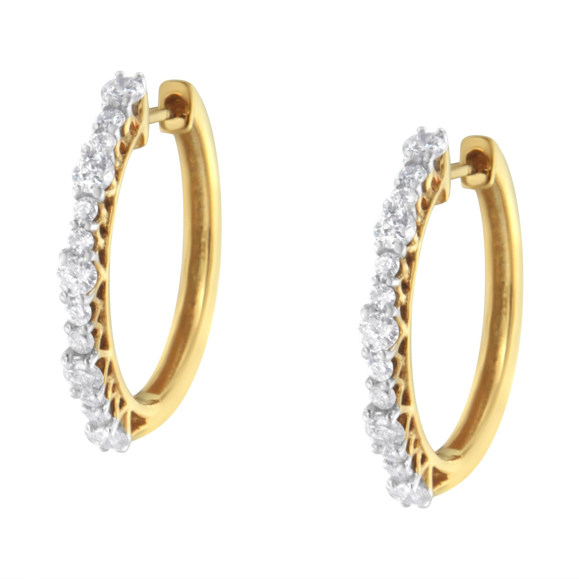 Pair of yellow metal hoop earrings with prong-set round white gemstones, shown from a side angle.