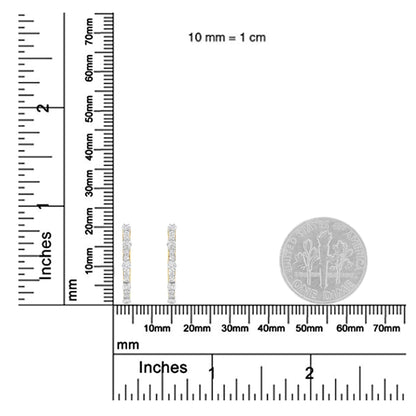 Pair of yellow metal earrings with multiple round white gemstones in prong settings, shown upright on a ruler and a dime for size reference, photographed from the front angle.
