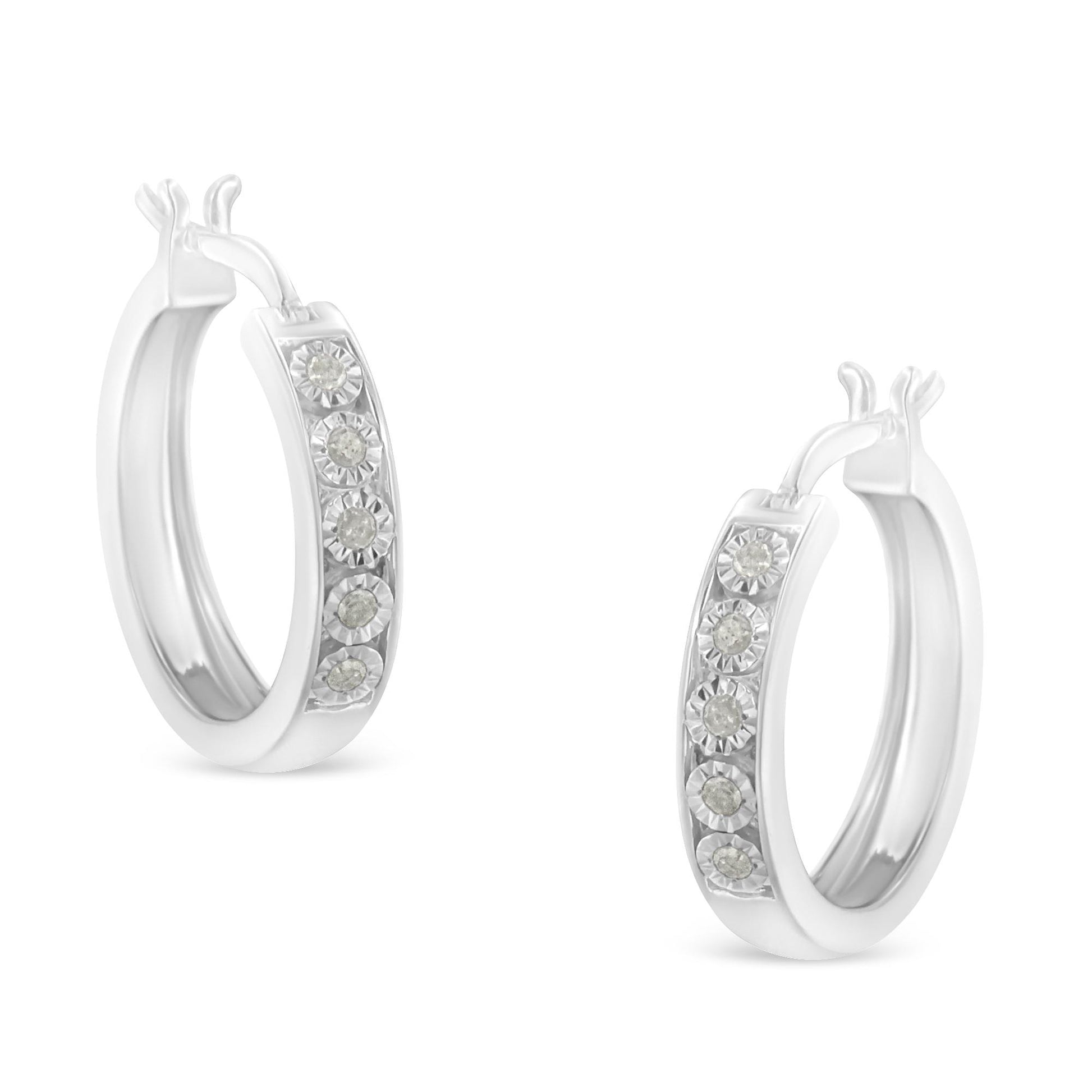 Pair of white metal hoop earrings with round white gemstones set in a row, shown from a front angle.