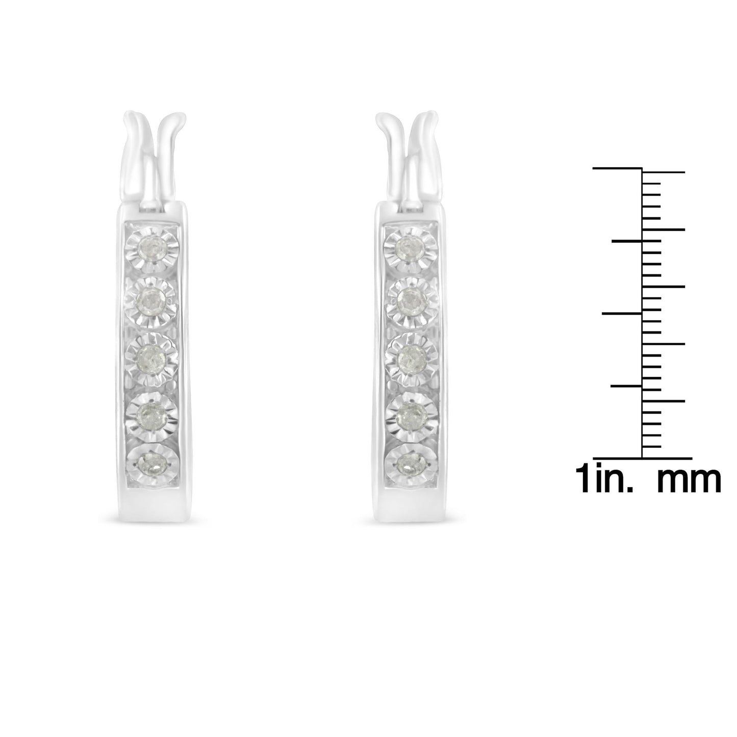 Front view of white metal earrings with five round white gemstones in miracle settings, shown next to a ruler for size reference.
