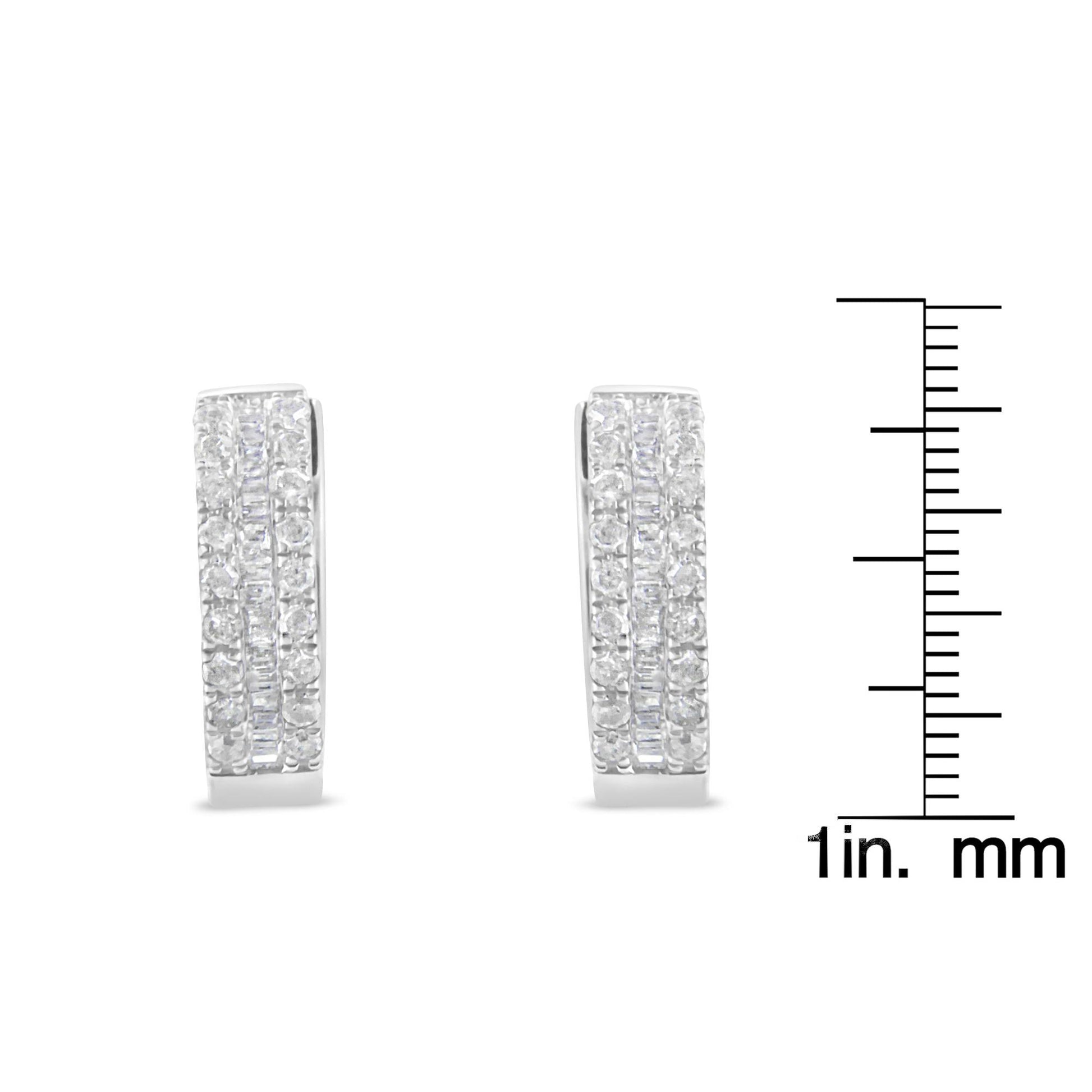 Front-facing shot of a pair of white metal earrings with rows of round pave-set white gemstones flanking a center row of channel-set baguette-shaped white gemstones, shown next to a ruler for size reference.