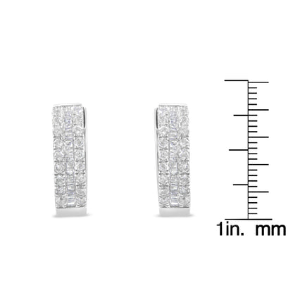 Front-facing shot of a pair of white metal earrings with rows of round pave-set white gemstones flanking a center row of channel-set baguette-shaped white gemstones, shown next to a ruler for size reference.