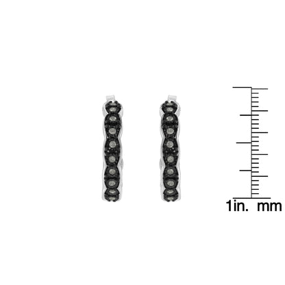 Front view of two-toned hoop earrings with round white gemstones in miracle setting, shown next to a ruler for size reference.