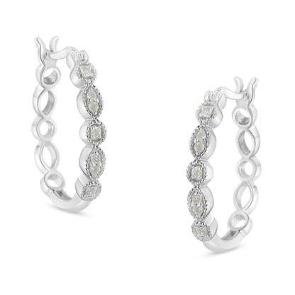 Pair of white metal hoop earrings with round white gemstones in prong settings, shown at an angled front view.
