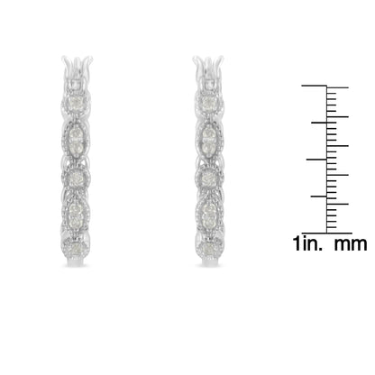 Front view of a pair of white metal earrings encrusted with round white gemstones in prong settings, displayed next to a ruler for size reference.