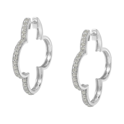 Front angled view of white metal earrings in a quatrefoil hoop shape with round white gemstones set in prongs along the outer edges.