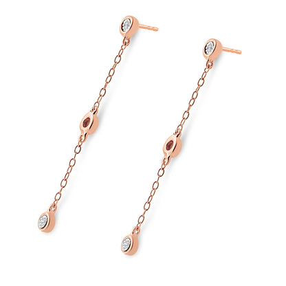 Pair of rose-colored metal drop earrings with chain links, white round gemstones set in a miracle setting at three points, shown from an angled top-down view.