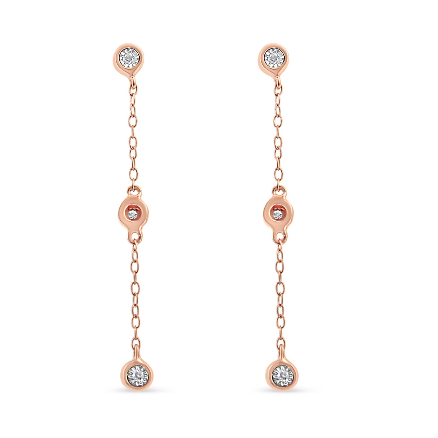 Front view of a pair of rose metal dangle earrings with three white gemstones in a miracle setting along each chain.