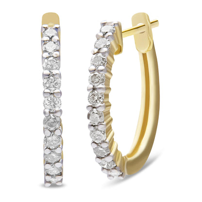 Front and side view of yellow metal hoop earrings set with round white gemstones in prong settings.