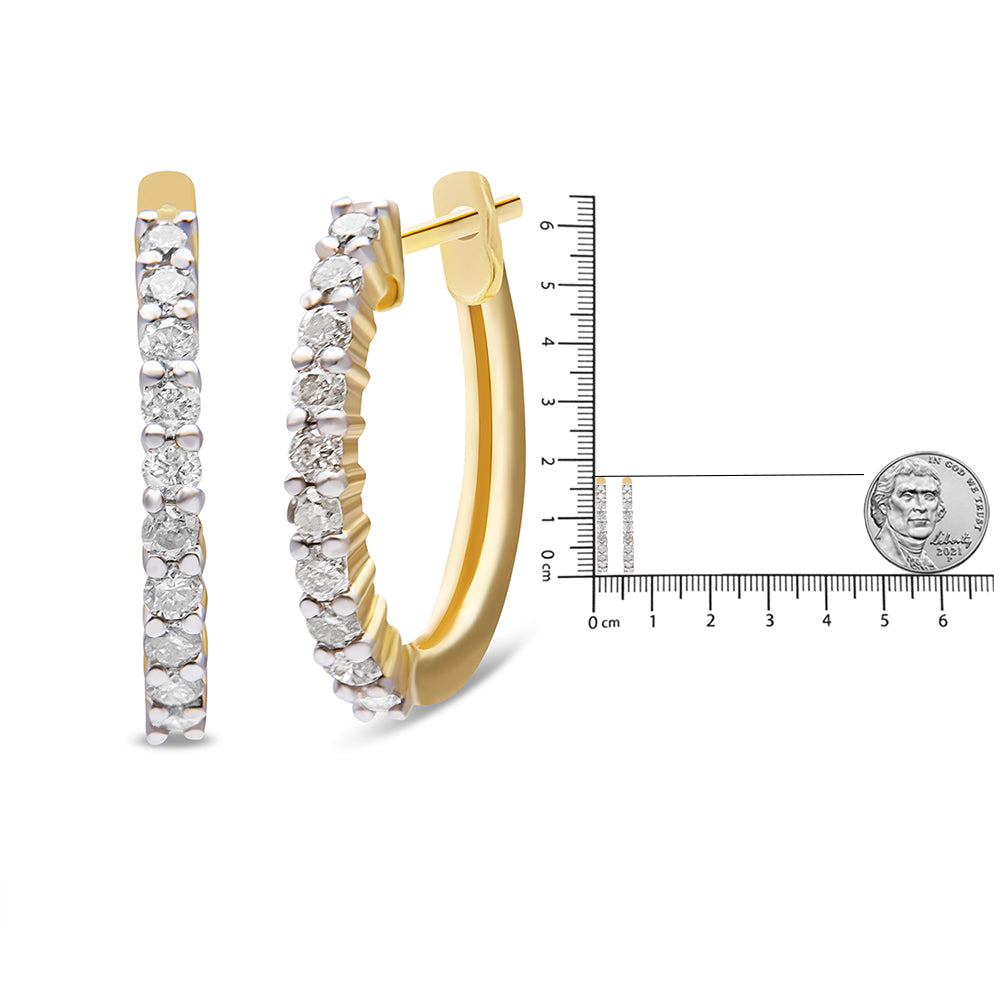 Pair of yellow metal hoop earrings with white round gemstones in prong settings, shown from front and side angles, displayed next to a ruler and coin for size reference.