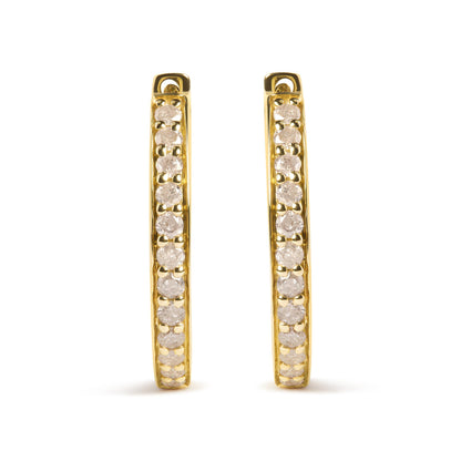Front-facing view of a pair of yellow metal hoop earrings with prong-set round white gemstones along the outer edge.