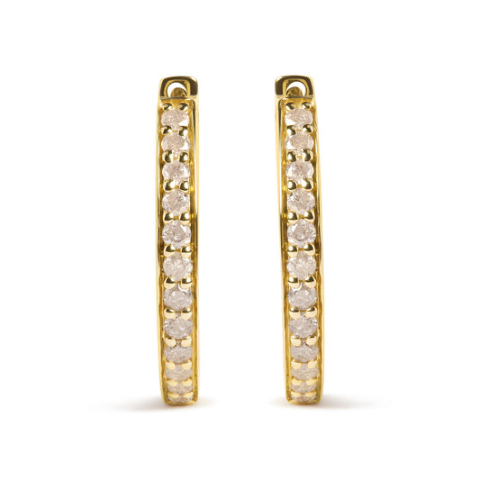 Front-facing view of a pair of yellow metal hoop earrings with prong-set round white gemstones along the outer edge.