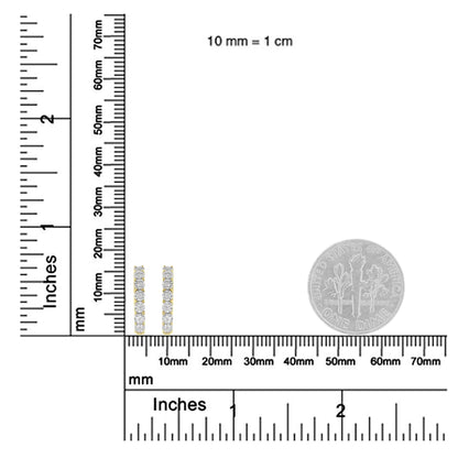 Close-up front view of two-toned metal earrings with a vertical row of round white gemstones shown on a ruler for size reference.