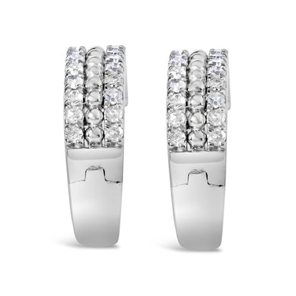 Front view of a pair of white metal hoop earrings with three rows of round white gemstones in a pave setting along the front.