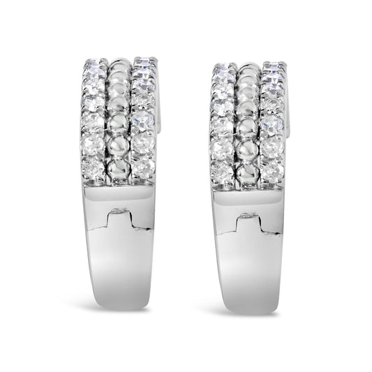 Front view of a pair of white metal hoop earrings with three rows of round white gemstones in a pave setting along the front.