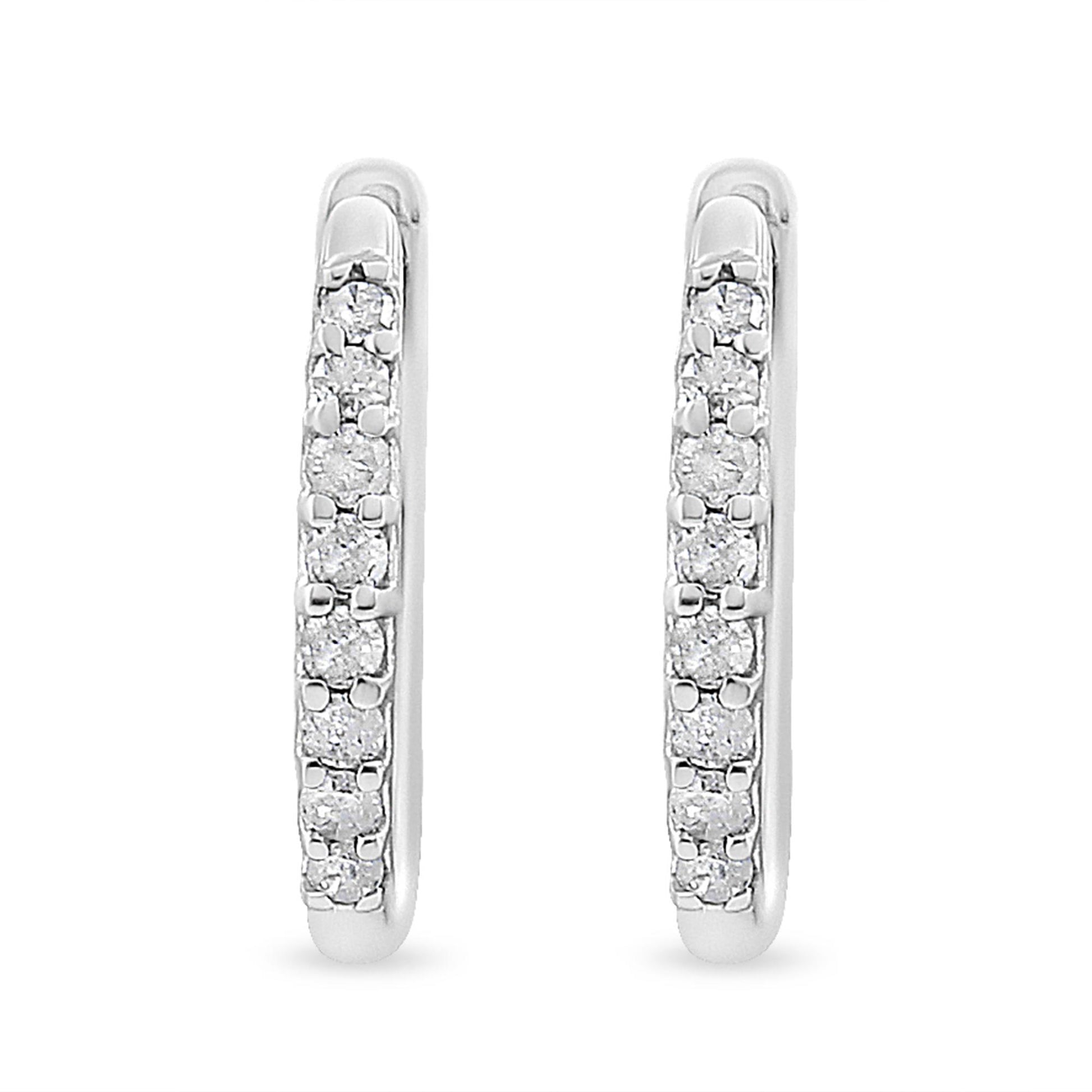 Front-facing close-up of white metal earrings set with round white gemstones in prong settings.