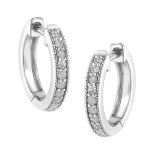 Close-up front angle of a pair of white metal hoop earrings with a row of round white gemstones in prong settings along the outer edge.