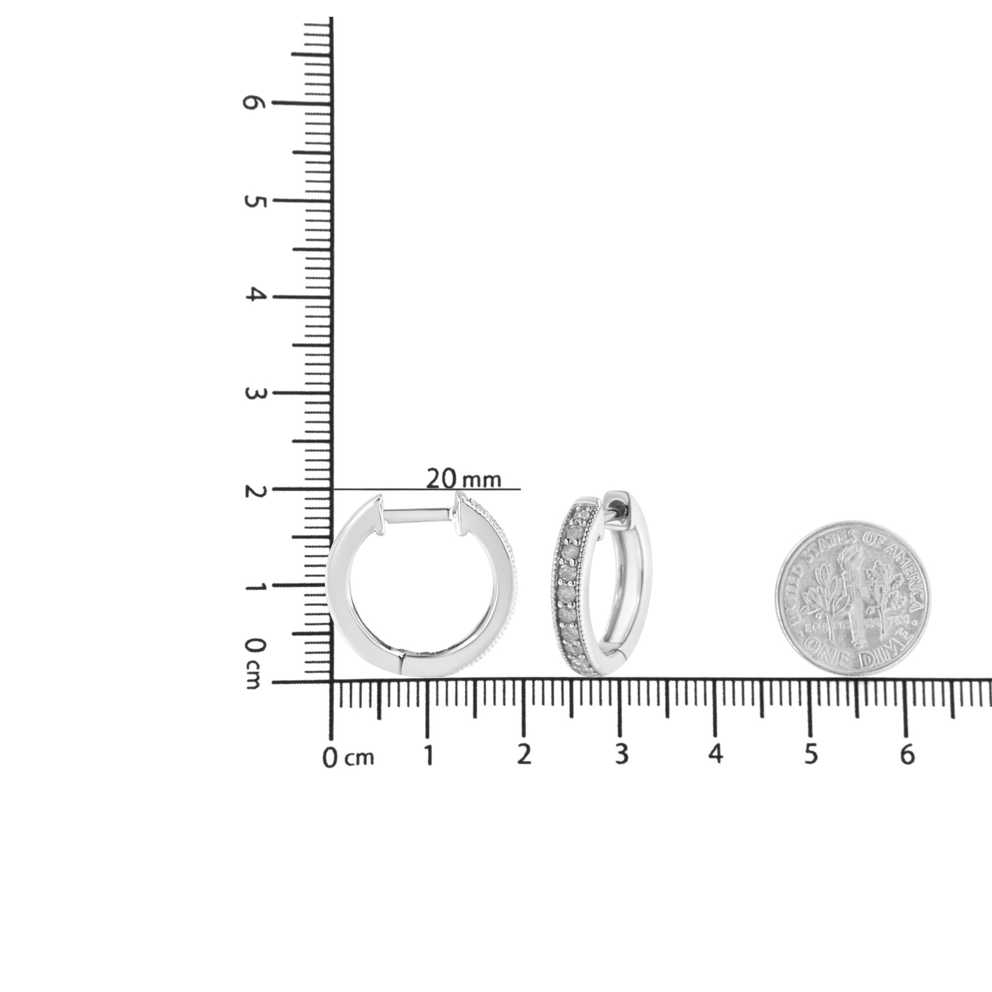 Pair of white metal hoop earrings with prong-set round white gemstones, shown on a ruler and next to a dime for size reference, photographed from the front and side angles.
