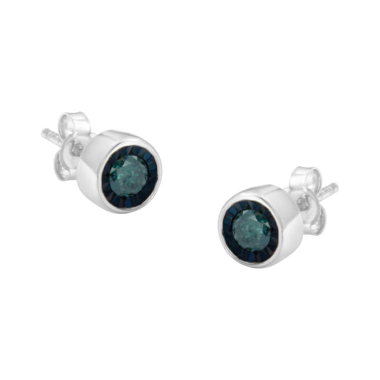 Pair of white metal stud earrings with round blue gemstones in miracle setting, shown at a slight angle.