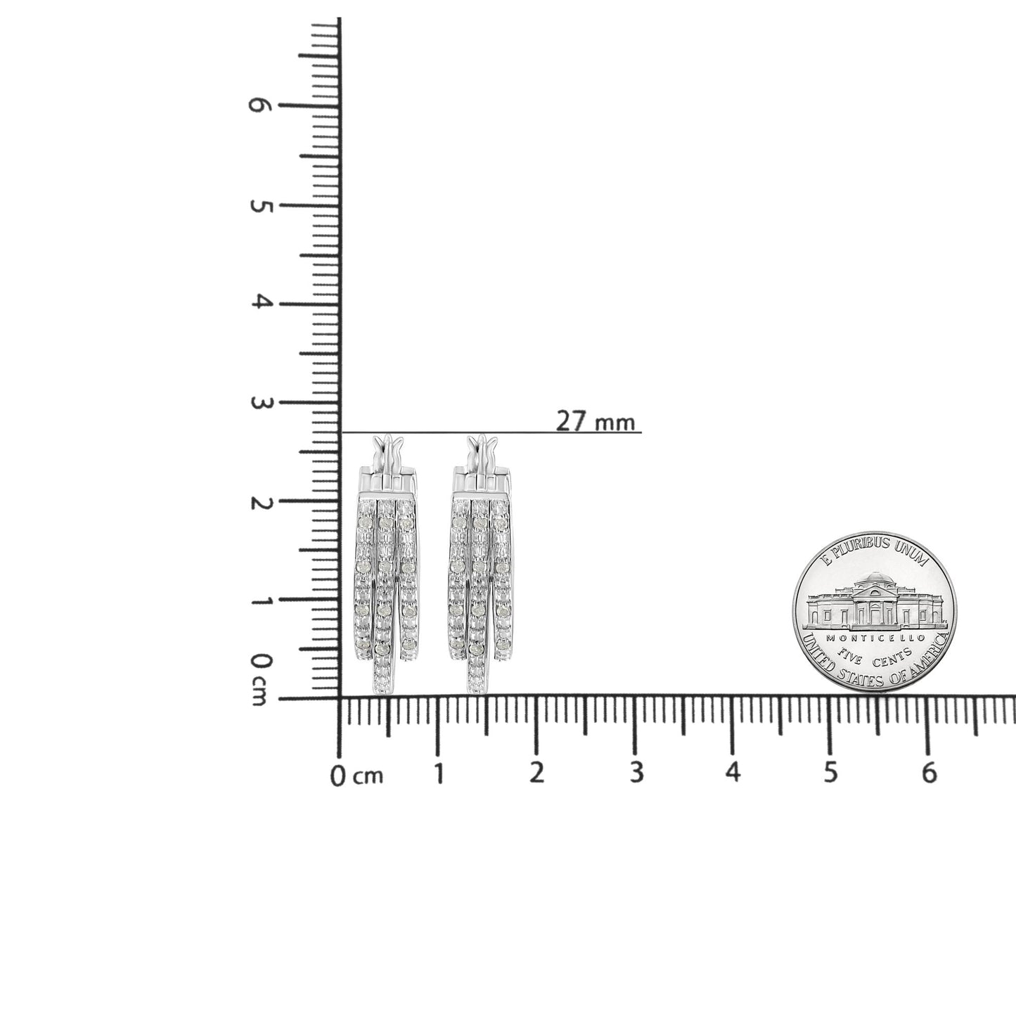 Front-facing image of white metal earrings with multiple rows of round white gemstones in pave setting, placed on a ruler for size reference.