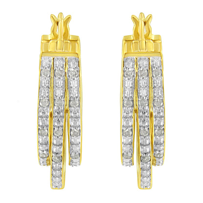 Front facing shot of a pair of yellow metal earrings featuring three vertical rows of white round pave-set gemstones.