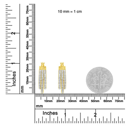 Pair of yellow metal earrings with three vertical rows of white round pave-set gemstones, shown from front angle on a ruler and scale for size reference with a coin.