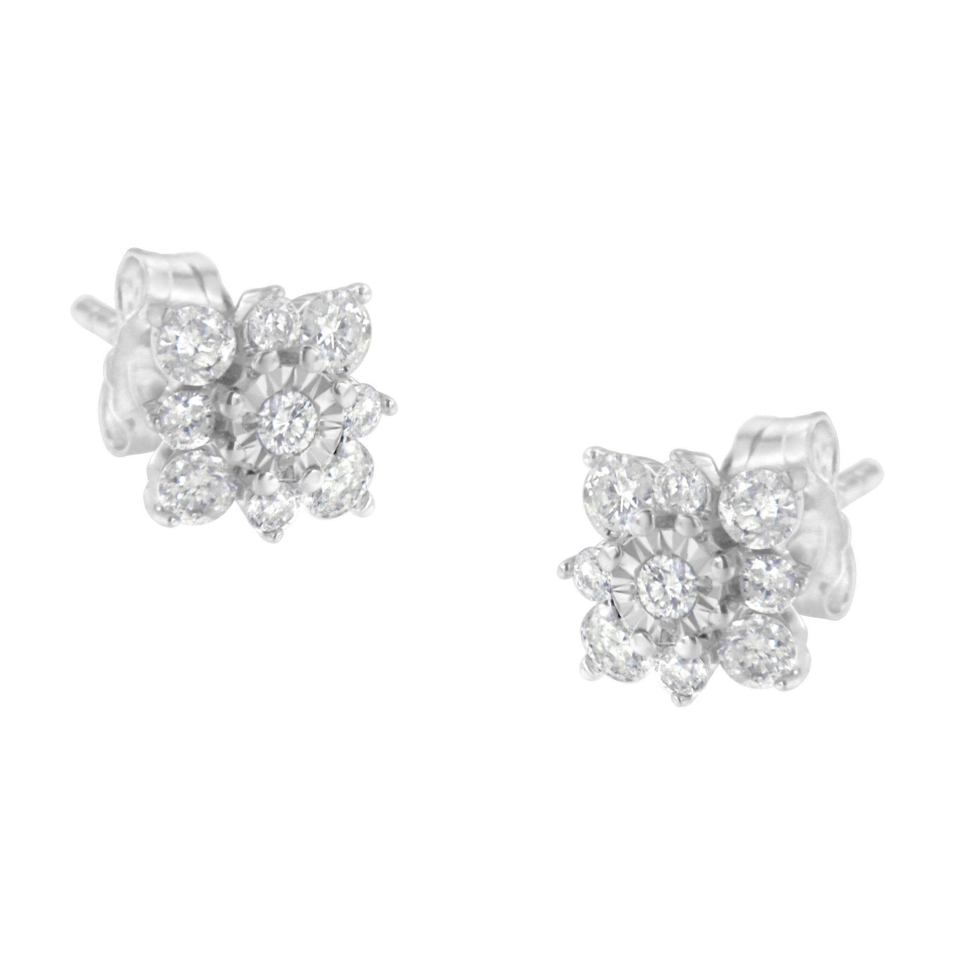 Pair of white metal stud earrings with round white gemstones in prong and miracle settings, shown at a slight angle on a white background.