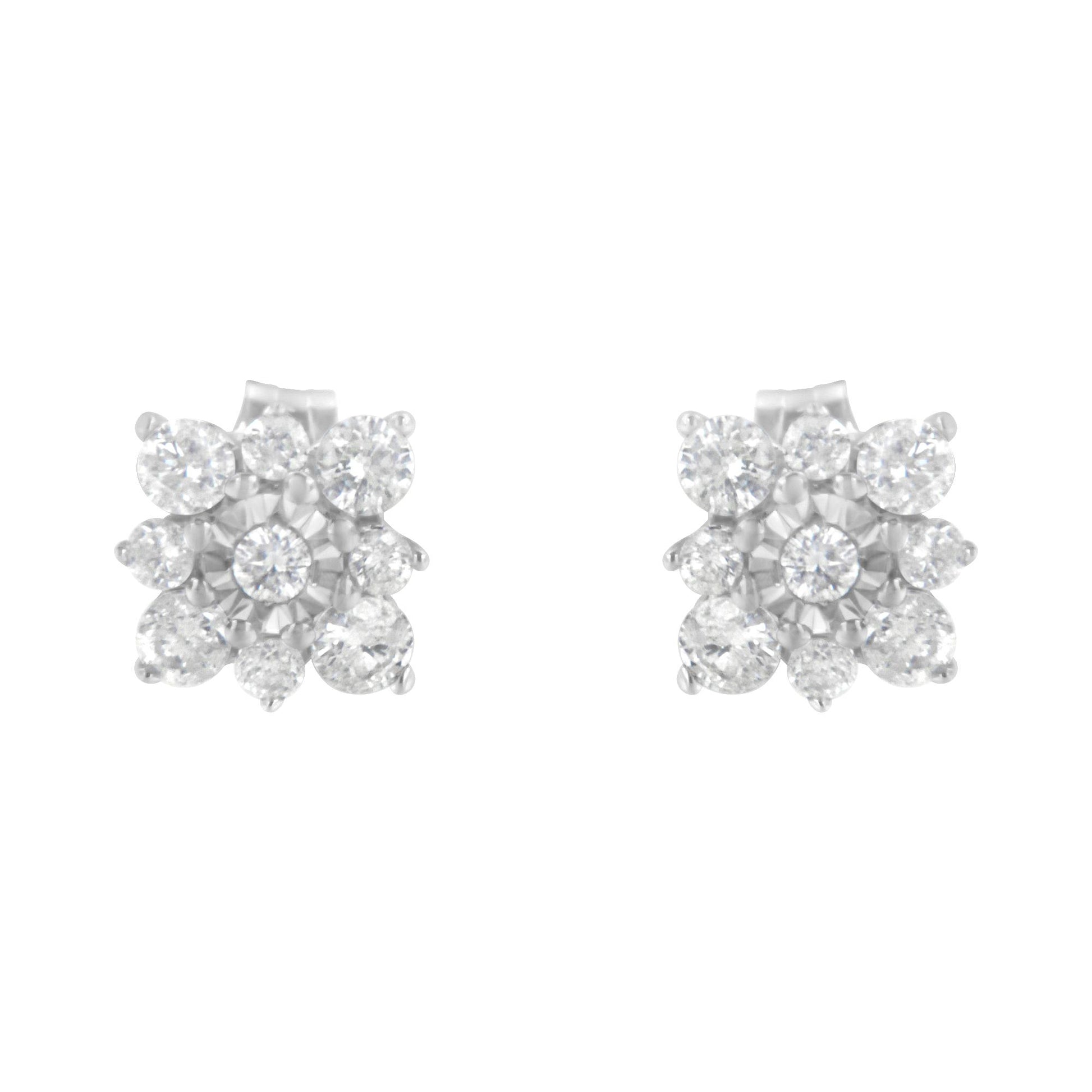 Front angled view of white metal stud earrings featuring multiple round white gemstones in prong and miracle settings arranged in a floral design.