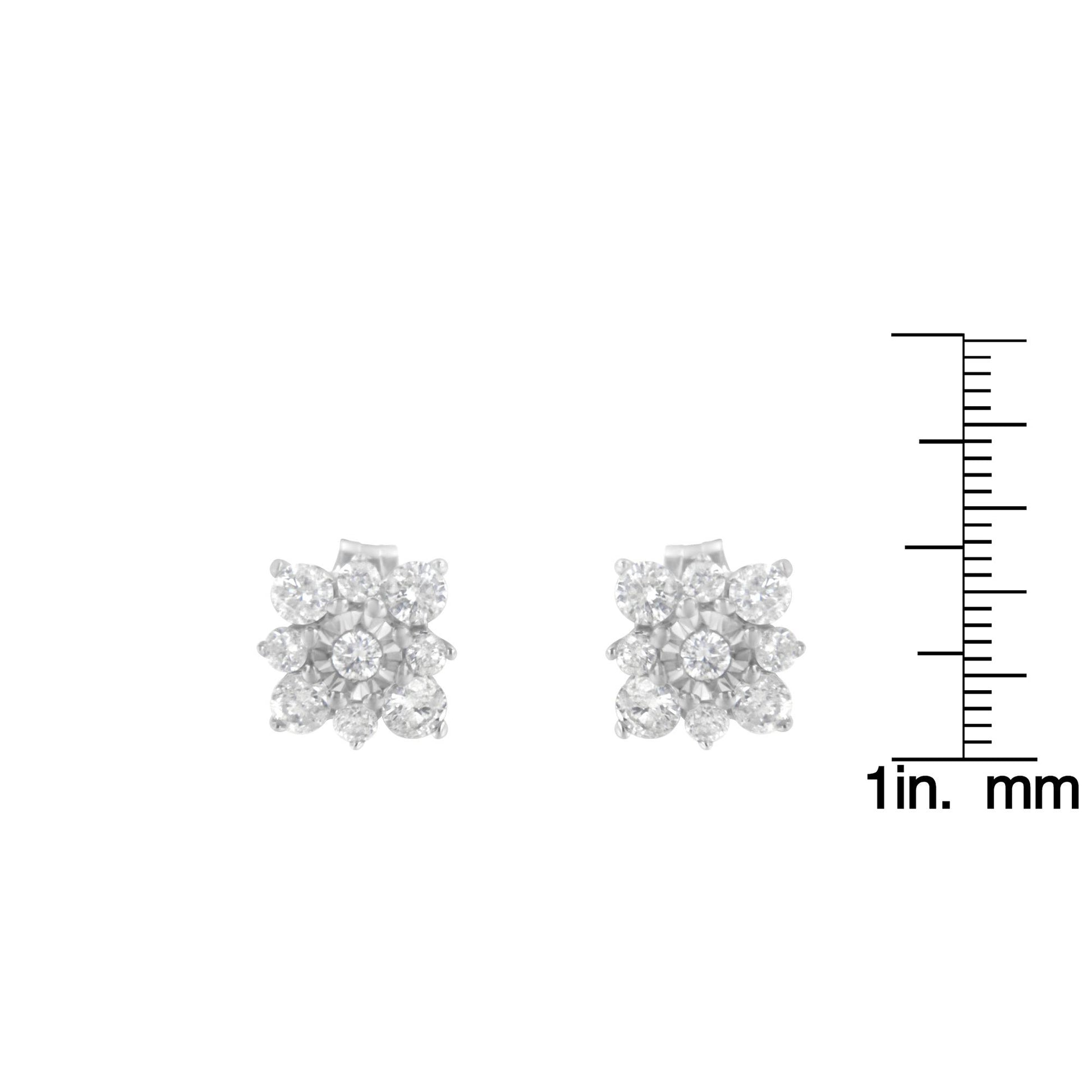 Front-facing view of white metal stud earrings with multiple round white gemstones in prong and miracle settings, shown next to a ruler for size reference.