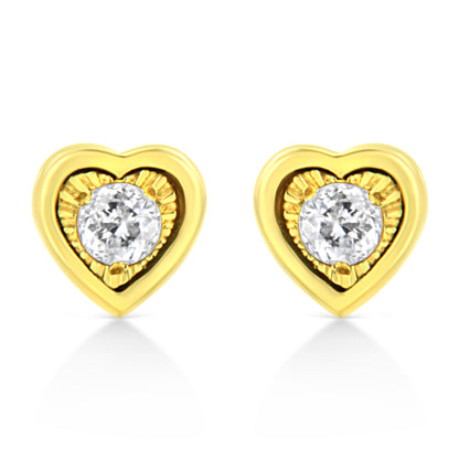 Front-facing shot of yellow metal heart-shaped earrings each set with a round white gemstone in a miracle setting with brownish accents.
