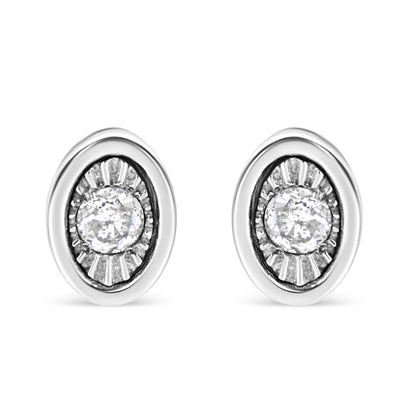 Front view of white metal oval earrings with a central round white gemstone in a miracle setting surrounded by textured detailing.
