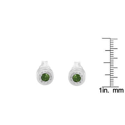 Front view of white metal stud earrings featuring round green gemstones in a miracle setting, displayed next to a ruler for size reference.