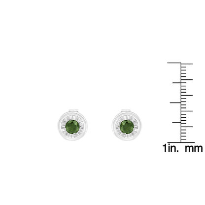Front angle view of white metal stud earrings with round green gemstones in miracle settings, shown next to a ruler for size reference.