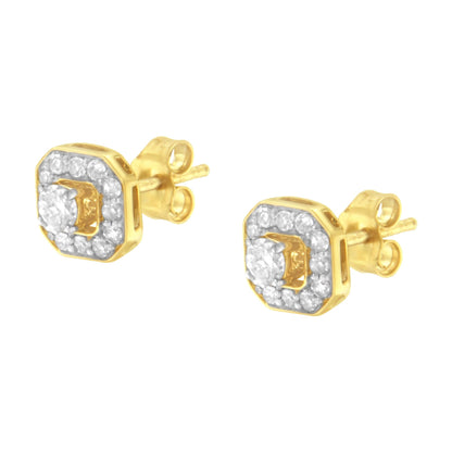 Front angled view of a pair of yellow metal stud earrings with a central round white gemstone in prong setting, surrounded by small round white gemstones in pave setting.