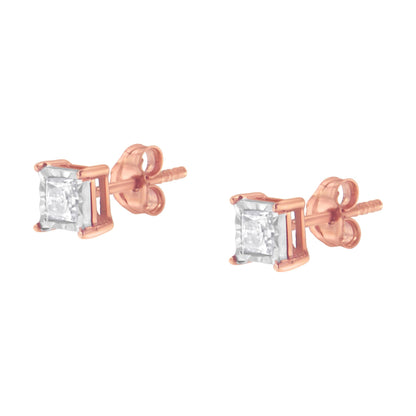 Pair of stud earrings with rose-colored metal setting and white princess-shaped gemstones, front angled view.