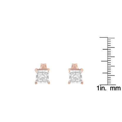 Front view of a pair of stud earrings with white and rose metal featuring square white gemstones, shown next to a ruler for size reference.